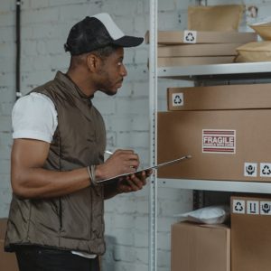 Courier checking packages in a warehouse, ensuring fragile handling
